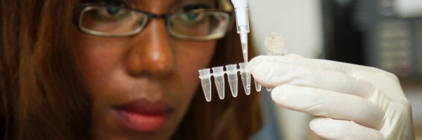 Een vrouw pipeteert in het lab