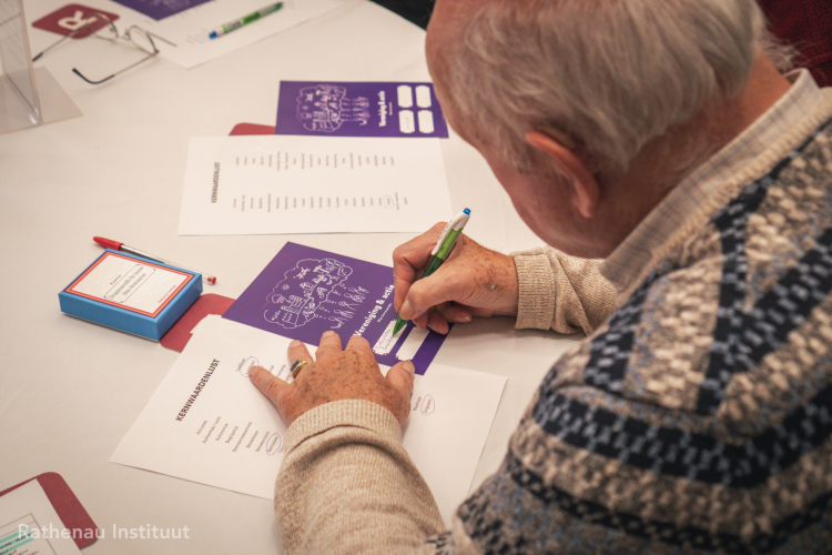Deelnemer schrijft op paarse kaart