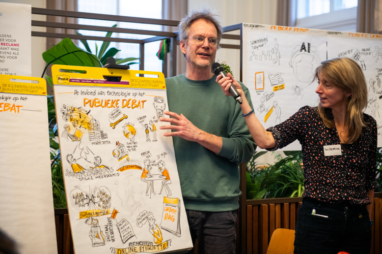 Tekenaar Jousma legt uit wat hij samen met zijn tafel getekend heeft