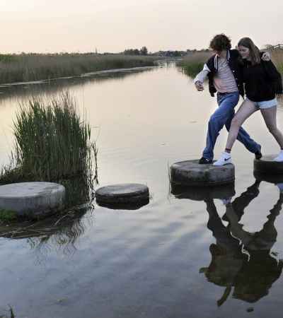 Samen stappen maken over stenen in het water
