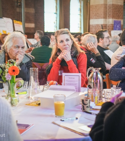 Mensen aan een tafel die naar elkaar luisteren
