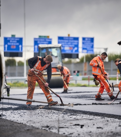 Mannen asfalteren snelweg.