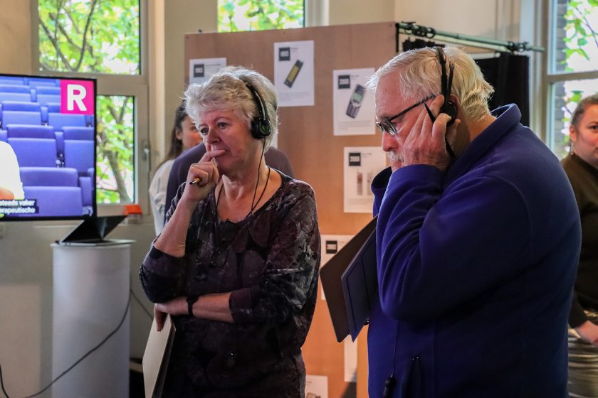 Twee deelnemers luisteren ter inspiratie naar een video over digitale relaties.