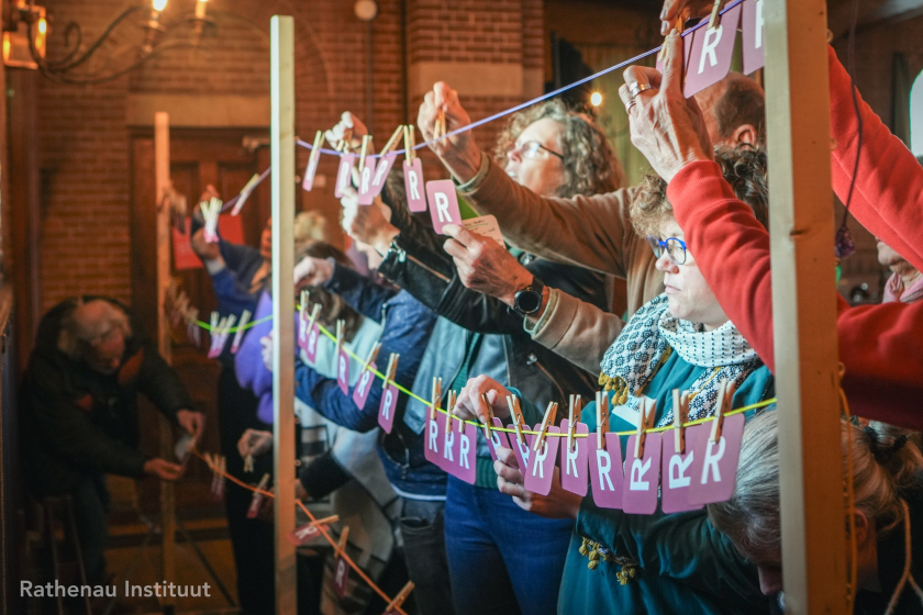 Mensen hangen kaartjes aan een waslijn