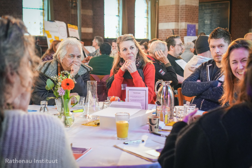 Mensen aan een tafel die naar elkaar luisteren