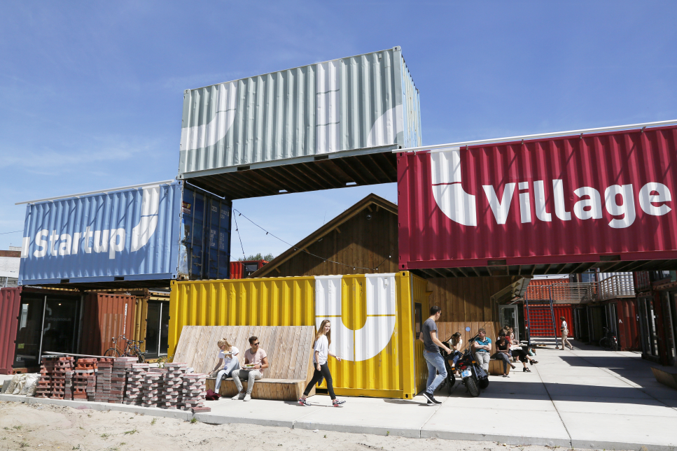 Foto van de Startup Village in Amsterdam, zeecontainers in verschillende kleuren