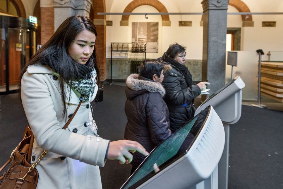 Een mevrouw trekt een nummer voor de balie van het Stadskantoor in Rotterdam