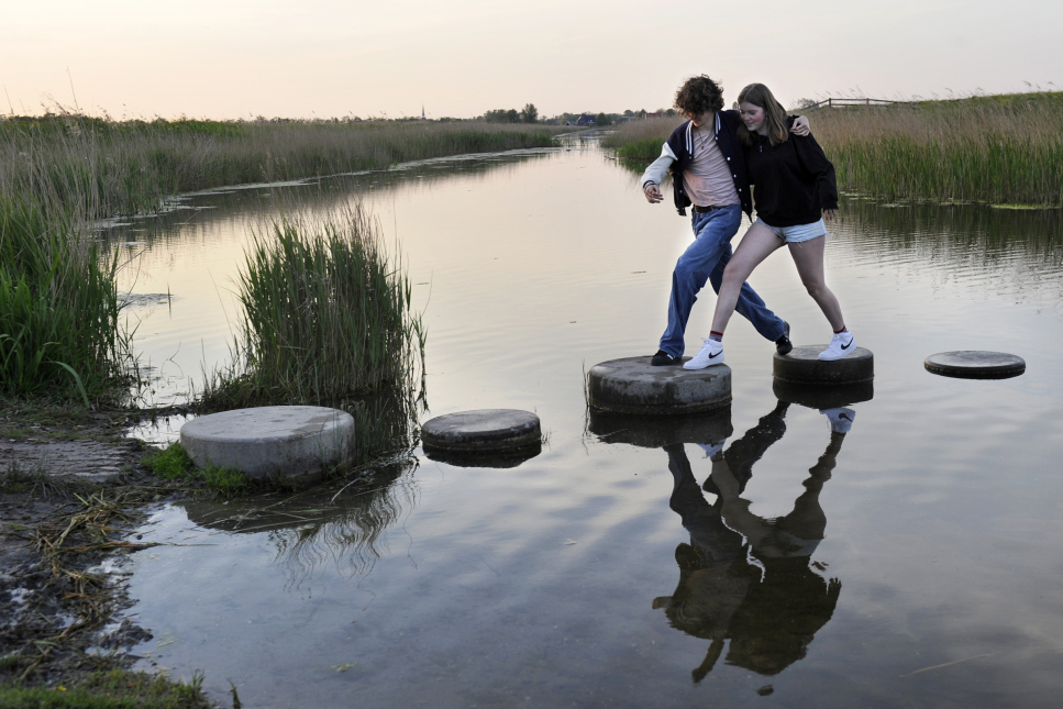Samen stappen maken over stenen in het water