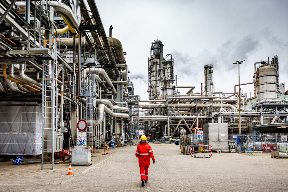 Persoon loopt over terrein bij chemische fabriek