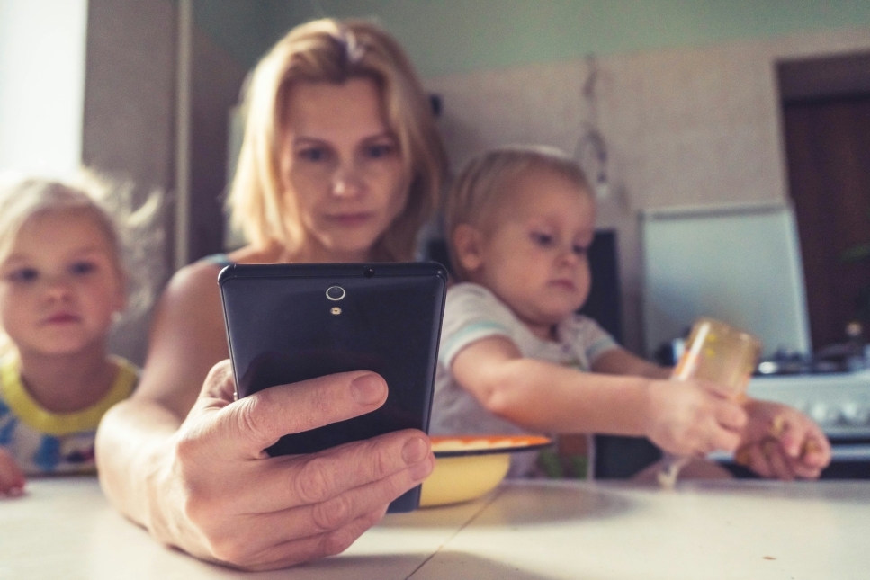 Vrouw met mobieltje en kinderen