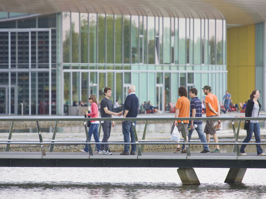 Twee mannen ontmoeten elkaar op een brug bij de High Tech Campus Eindhoven