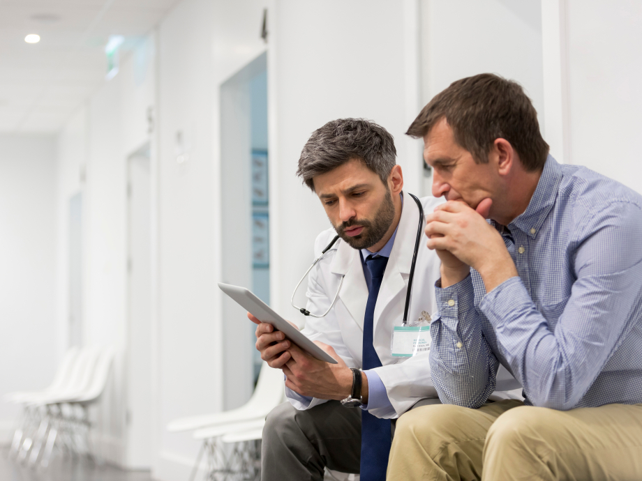 A doctor and patient discuss what's on their tablet screen