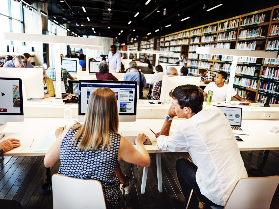 Mensen aan het werk achter laptops in een universiteitsbibliotheek