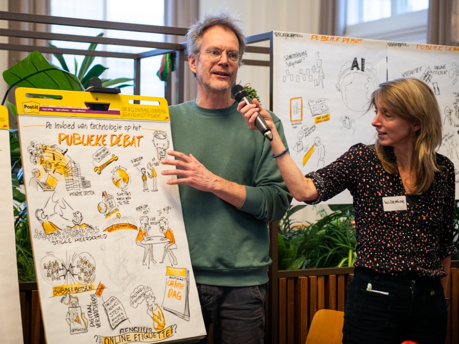 Tekenaar Jousma legt uit wat hij samen met zijn tafel getekend heeft