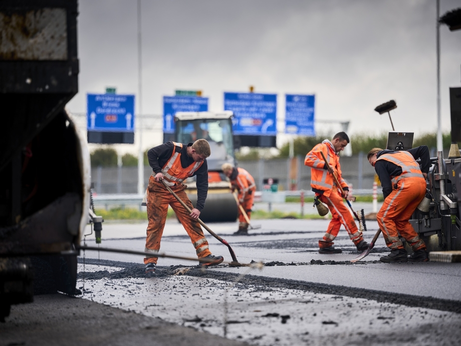 Mannen asfalteren snelweg.