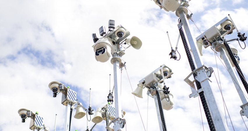 Een woud van surveillancecamera's tegen een bewolkte hemel