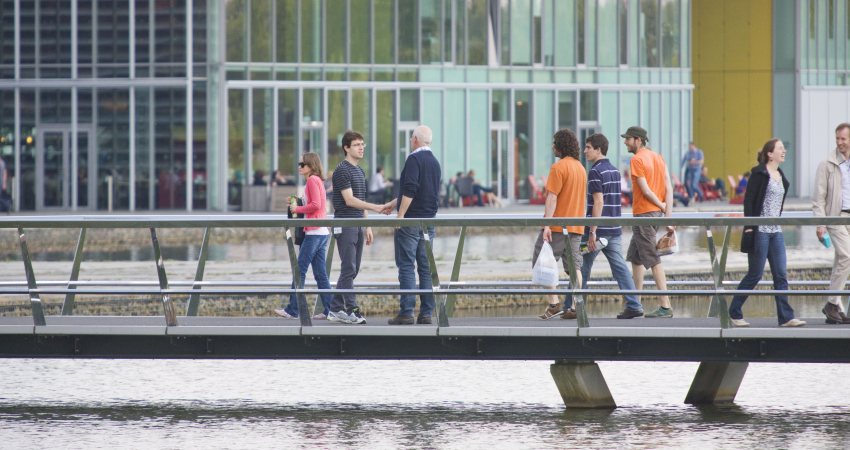 Twee mannen ontmoeten elkaar op een brug bij de High Tech Campus Eindhoven