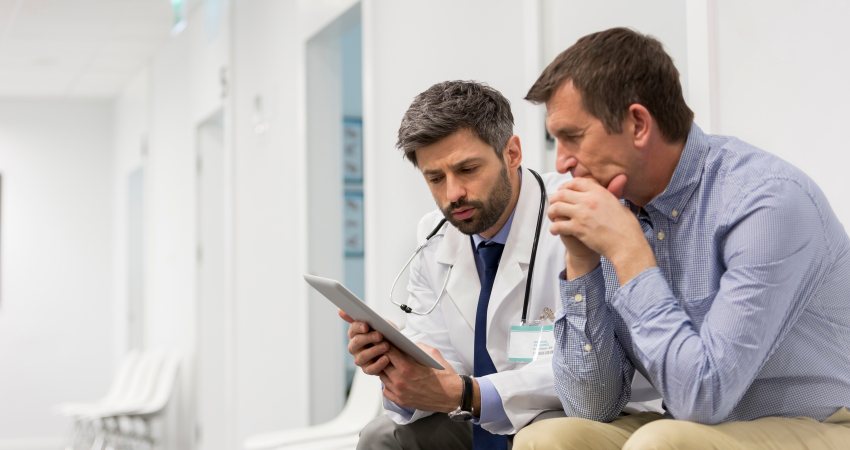 A doctor and patient discuss what's on their tablet screen