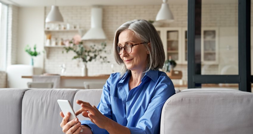 Een vrouw kijkt op haar smartphone