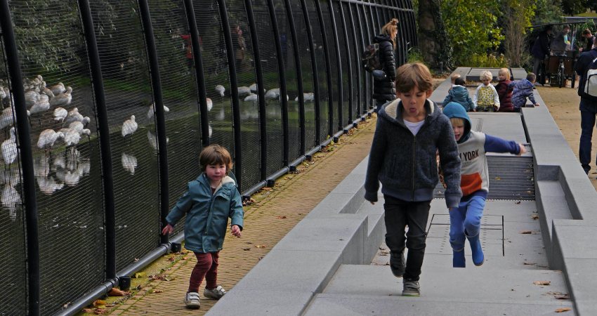 Kinderen spelen in een (droogstaande) fontein bij Artis