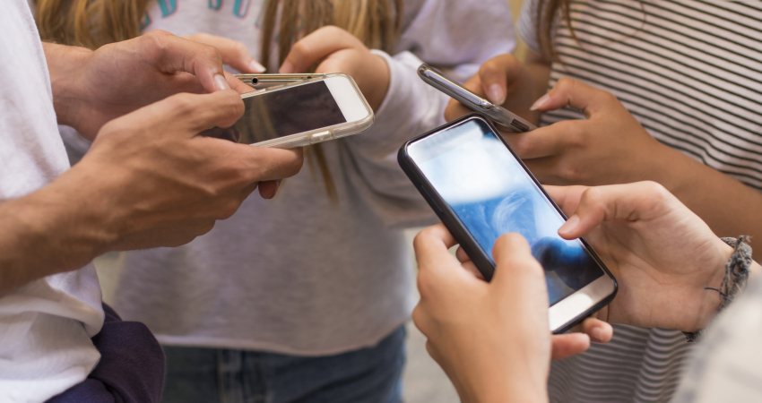 Groep jongeren op straat met hun mobiele telefoons