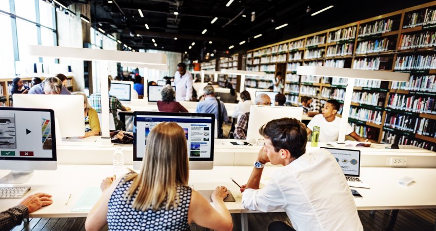 Mensen aan het werk achter laptops in een universiteitsbibliotheek