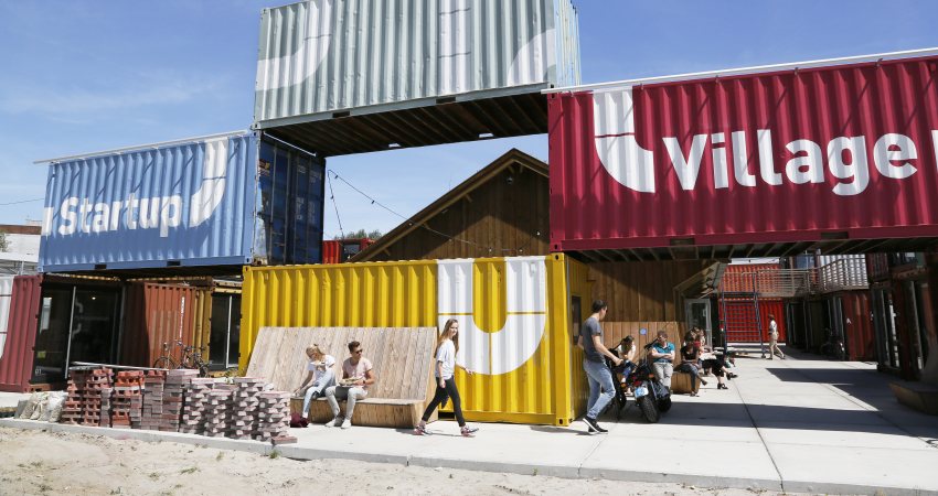 Foto van de Startup Village in Amsterdam, zeecontainers in verschillende kleuren