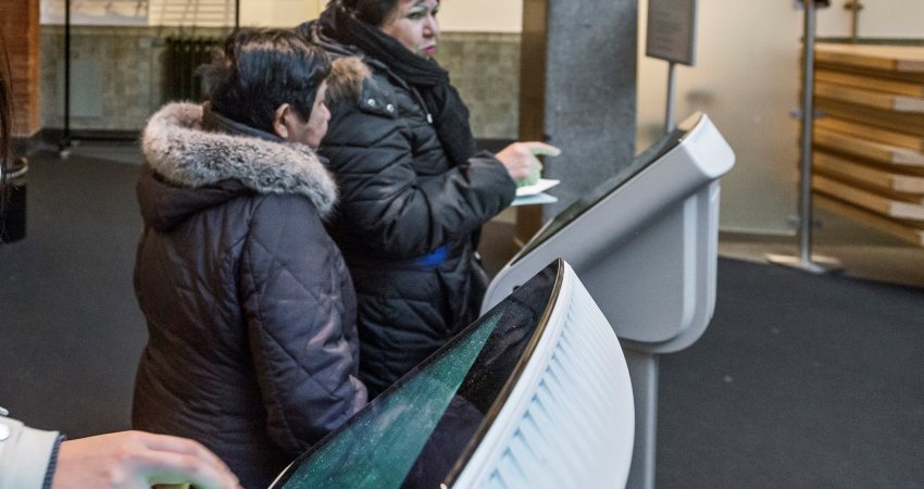 Bezoekers trekken een nummer voor de balie in Rotterdam