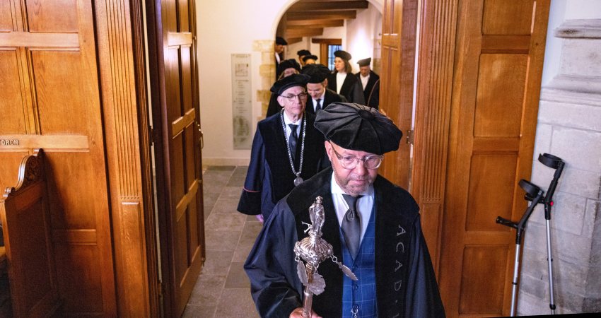 Leidse hoogleraren lopen in toga naar het academiegebouw