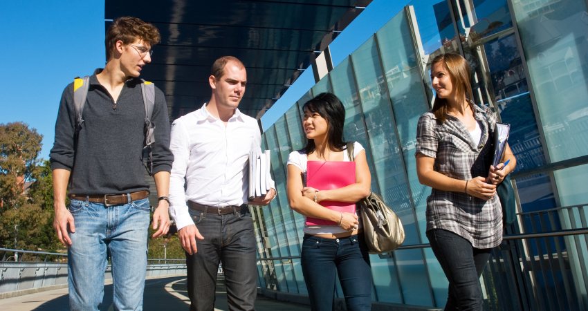 Vier jonge mensen lopen te praten 