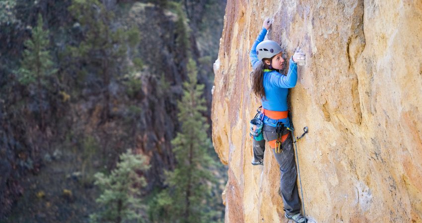 Een vrouw beklimt mer voorzorgsmaatregelen een berg