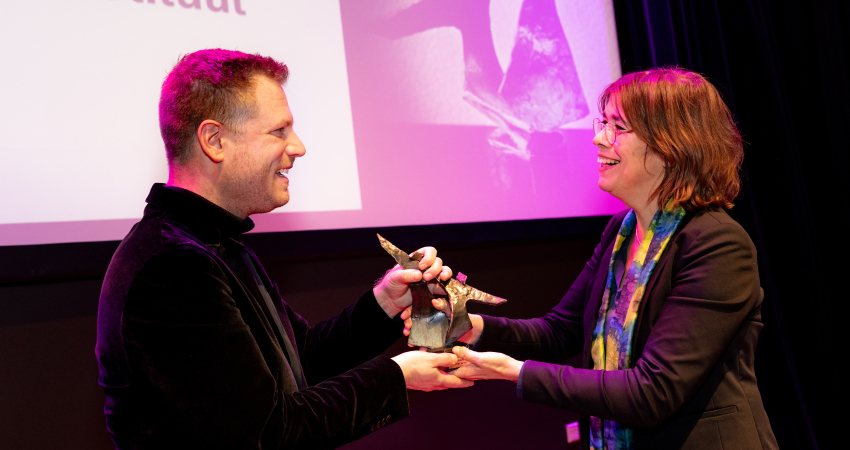 Bart Wernaart krijgt de Melanie Petersprijs uit handen van juryvoorzitter Daan Rovers