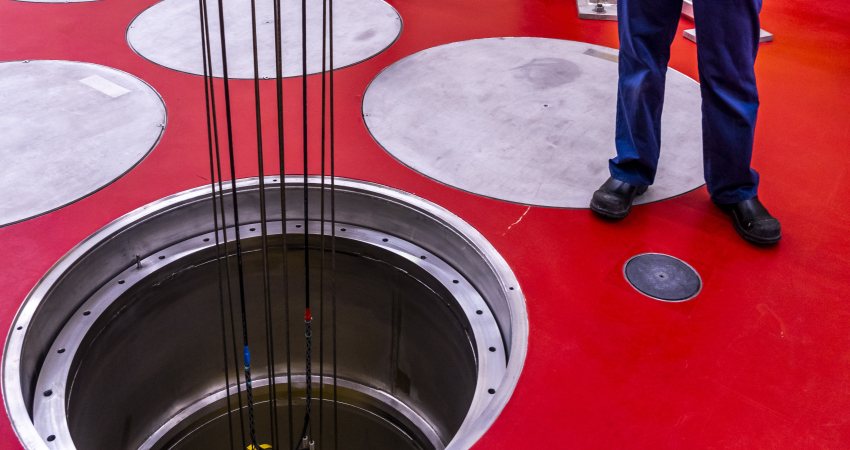 Een journalist kijkt in een van de schachten waarin COVRA tijdelijk hoog-radioactiefafval opslaat.