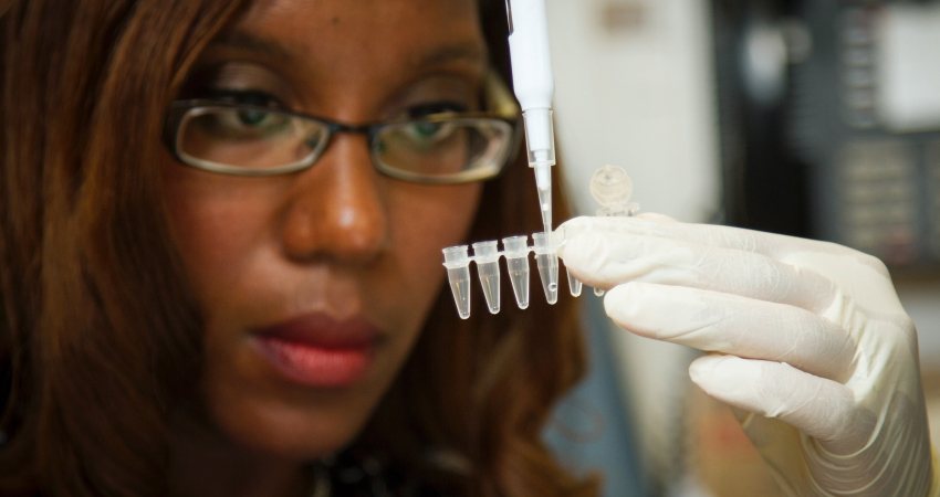 Een vrouw pipeteert in het lab