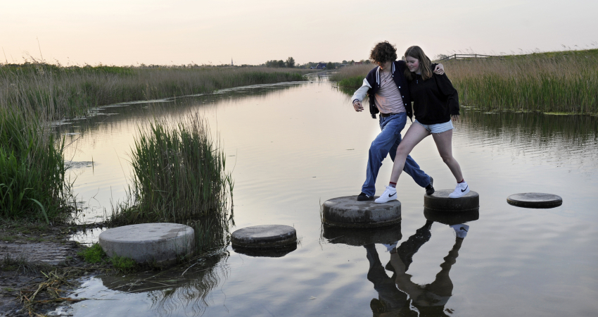 Samen stappen maken over stenen in het water