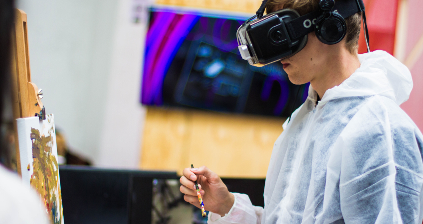 Jongen die met VR-bril op schildert