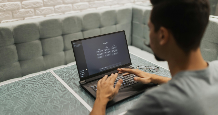 Man met laptop met daarop ChatGPT