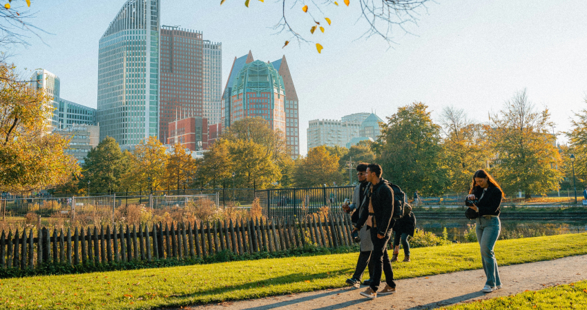 Mensen wandelen in park met op achtergrond skyline Den Haag