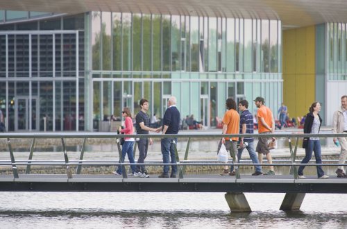 Twee mannen ontmoeten elkaar op een brug bij de High Tech Campus Eindhoven