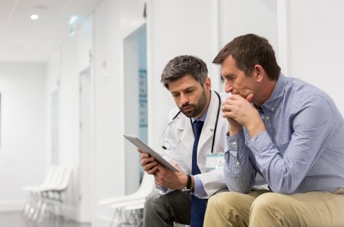 A doctor and patient discuss what's on their tablet screen