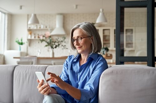 Een vrouw kijkt op haar smartphone