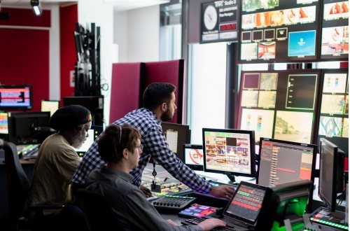 Medewerkers kijken in de control room mee op de verschillende schermen