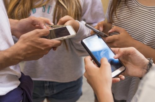 Groep jongeren op straat met hun mobiele telefoons