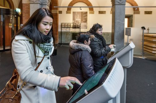 Een mevrouw trekt een nummer voor de balie van het Stadskantoor in Rotterdam