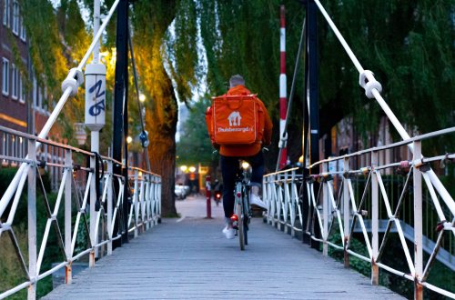 Een bezorger van Thuisbezorgd fietst over een brug