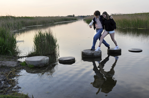 Samen stappen maken over stenen in het water