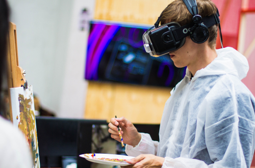 Jongen die met VR-bril op schildert 