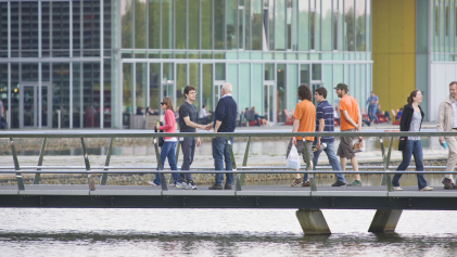 Twee mannen ontmoeten elkaar op een brug bij de High Tech Campus Eindhoven