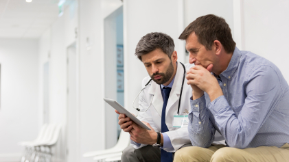 A doctor and patient discuss what's on their tablet screen