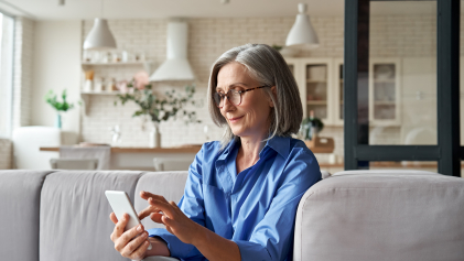 Een vrouw kijkt op haar smartphone